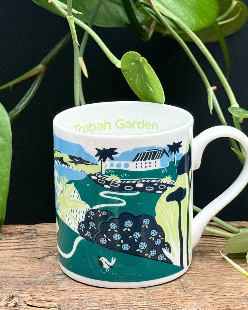 Mug with a scenic design on a wooden surface with plants