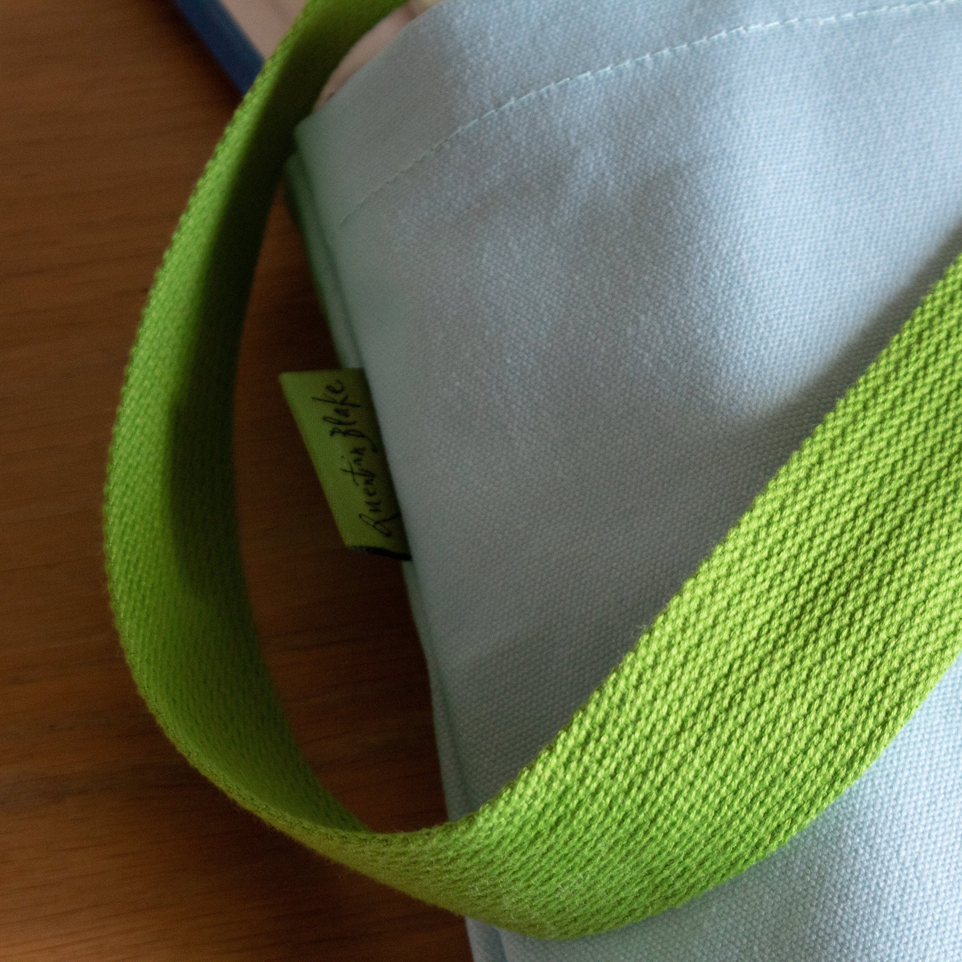Close-up of a green strap on a white surface with a wooden background