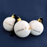 Three white ornaments with &