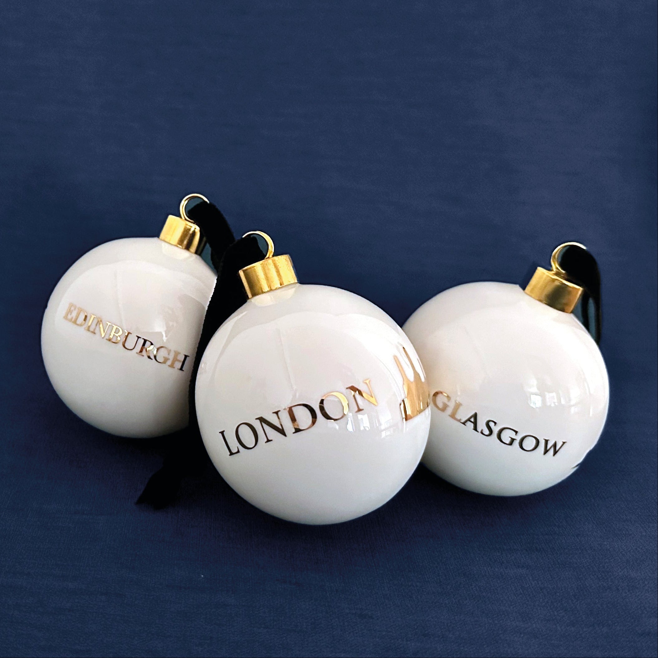 Three white ornaments with &