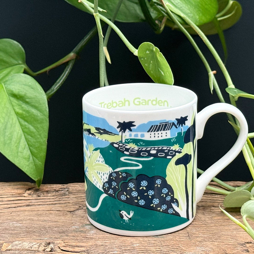 Mug with a scenic design on a wooden surface with plants